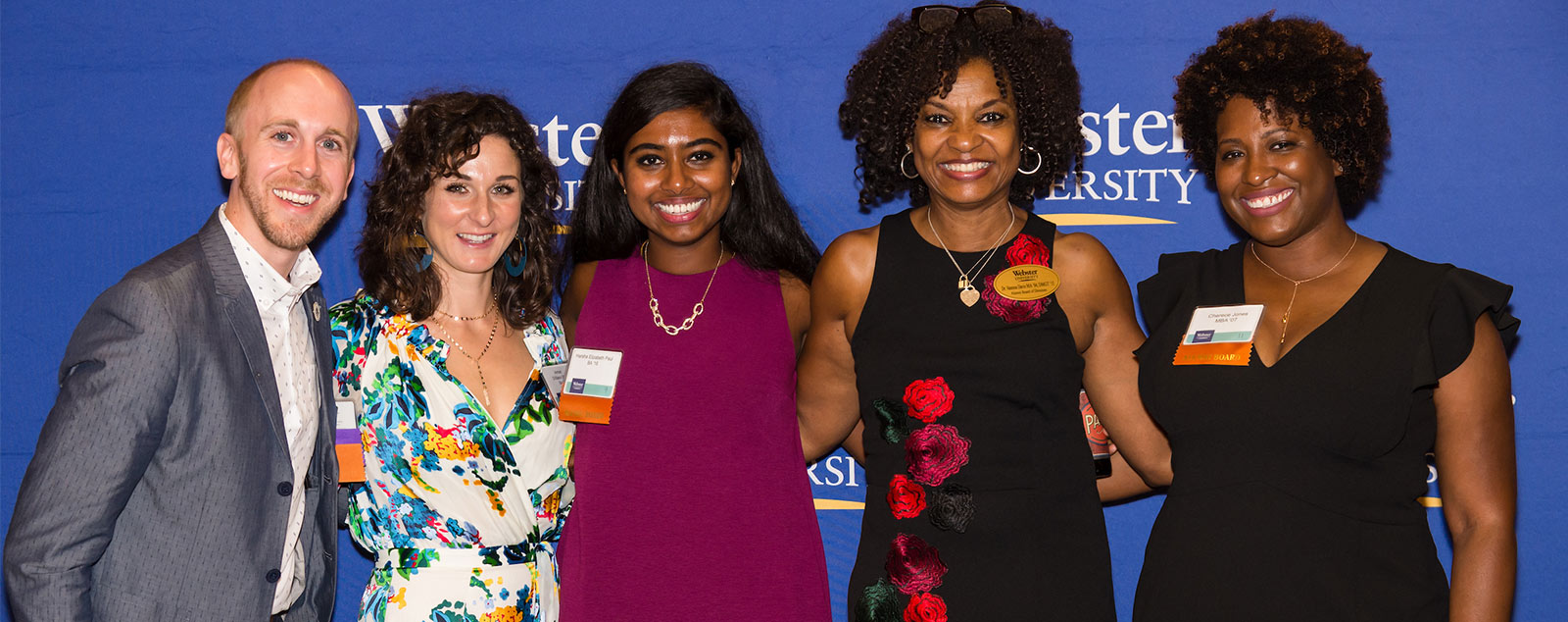 Five Webster alumni of diverse age, race, gender, and nationality pose together at the Alumni Awards celebration.