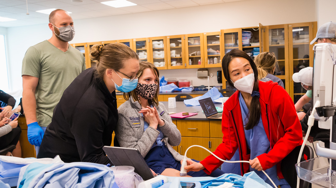Nurse anesthesia students in class using monitoring equipment